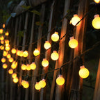 String of round lights hanging against a wooden fence