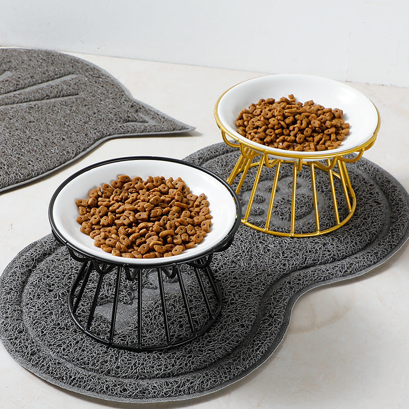Two elevated pet bowls filled with kibble on a textured mat.